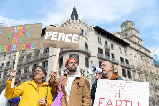 Activists with signs and megaphone protesting outdoors in Barcelona