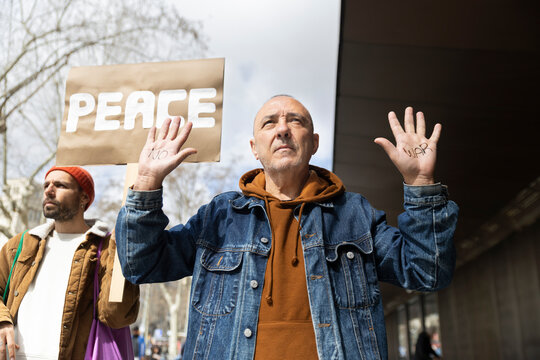 Activist showing no war message on hands during a peace protest