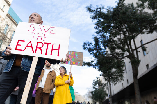 Activist holding a Save the Earth sign during a protest in Barcelona