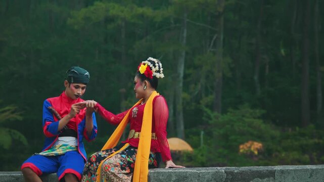 Indonesian Dancers Seated, Sharing an Intimate Moment Outdoors
