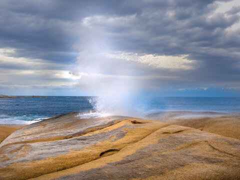 Bicheno blowhole (marine geyser) surrounded by stunning lichen-covered granite boulders, Bicheno, Tasmania, Australia