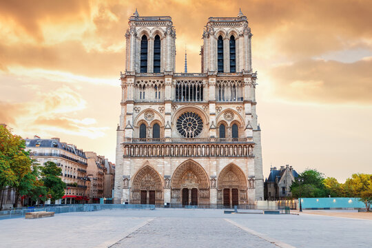 Majestic Notre-Dame de Paris main entrance at sunset, dramatic storm clouds