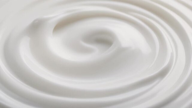 Close-up of smooth white cream swirled into circular patterns on a plain background