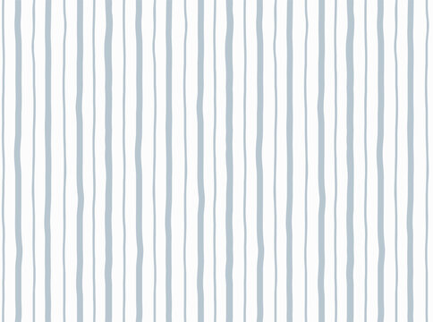 Seamless hand drawn vertical stripe pattern with irregular dusty blue wavy lines of varying width on white background. Simple organic minimal design for fabric, wallpaper, nursery and stationery.