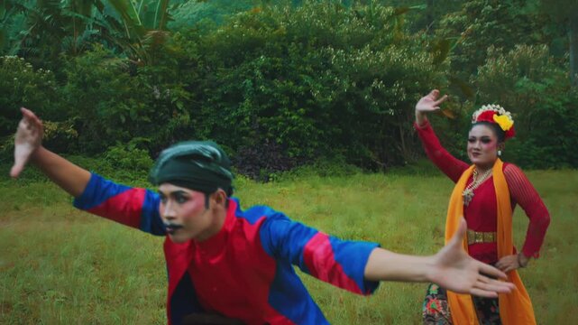 Traditional Indonesian Dancers Performing with Open Arms in Tropical Setting