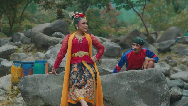 Traditional Indonesian Couple Striking Dynamic Poses on Natural River Rocks