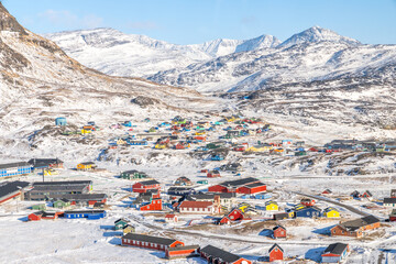 Aerial winter panorama of a Greenlandic village with bright wooden houses and snow-covered hills, Narsaq, Kujalleq, Greenland © vadim.nefedov
