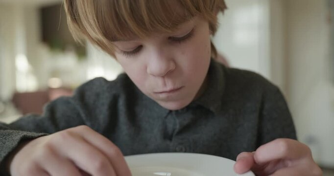 Kid Boy Eats Corn Flakes Meal in Kitchen. 4K 10-bit
