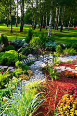 Obraz premium Serene Garden Landscape with Stone Path and Bridge Beneath Birch Trees