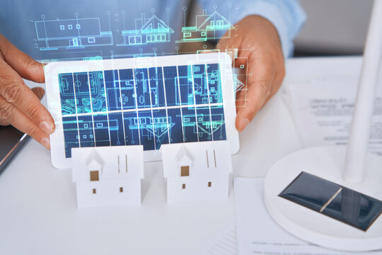 Architect holding solar panel with smart city hologram indoors