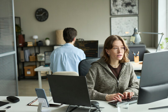 Programmer coding on computer in corporate office