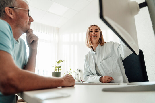 Doctor advising patient while looking at computer monitor