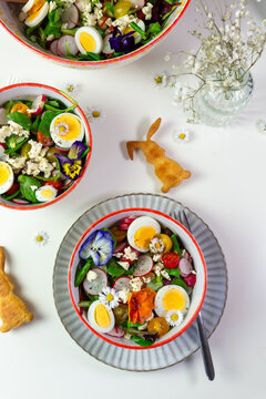 Fresh Easter salad with egg and edible flower directly above