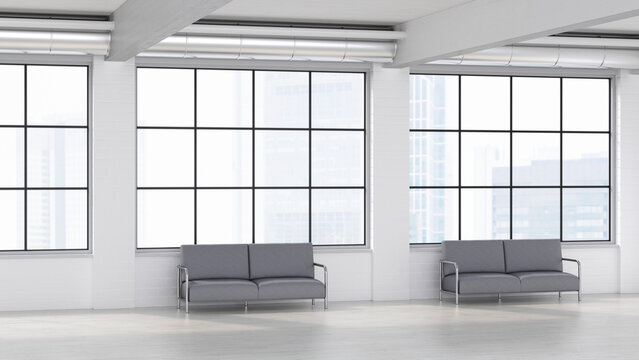 Modern empty loft waiting area with gray sofas and large windows