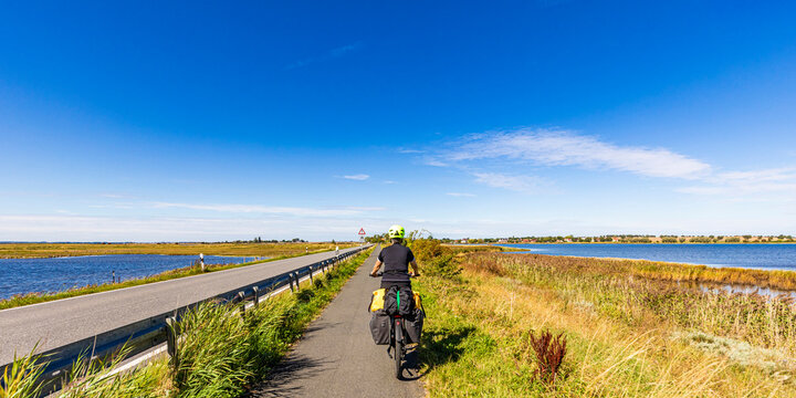 Woman rides e-bike on Baltic Sea cycle path in Poel Germany outdoors