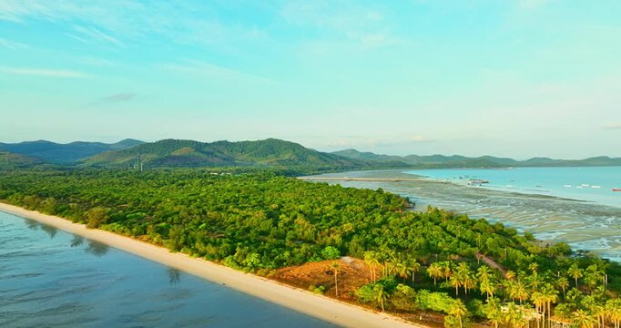 A mesmerizing aerial view of Laem Haad sandbar reveals dragon scale patterns beneath shallow waters. Tourists stroll along the white strip linking two island, forming a surreal tropical scene.