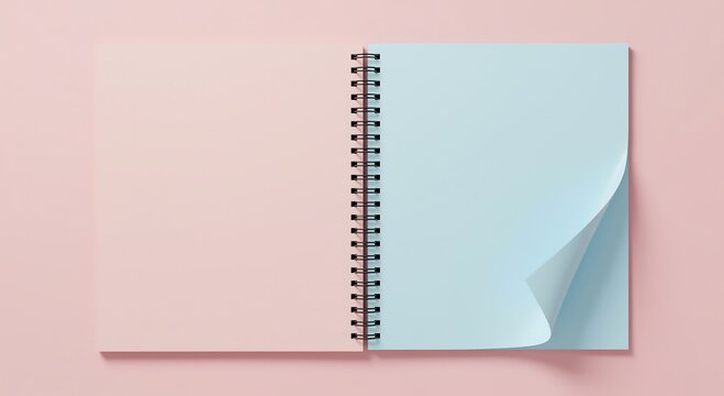Open spiral bound notebook with pastel pink and light blue pages on a pale pink background