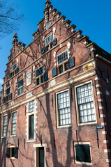 Obraz premium Historic brick building with large windows in a city under bright blue sky during daytime