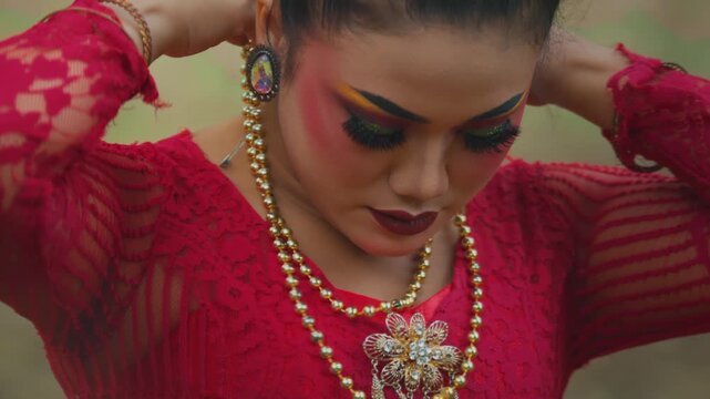 Dancer Putting on Golden Necklace for Traditional Performance