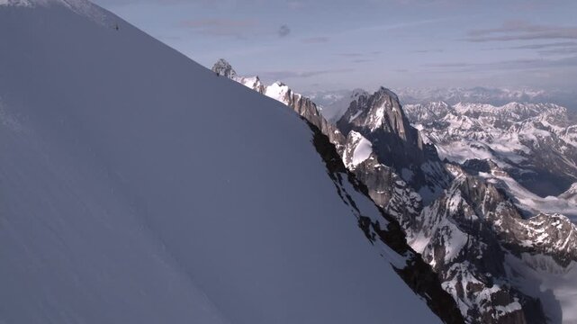 Freeride skier skiing down a steep mountain face covered in fresh powder snow in the Alps