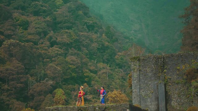 Couple in Traditional Costume Admiring Mountain Landscape