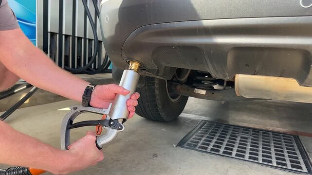 A man connect a gas hose to fill a car with gas through an adapter. Closeup. 4k