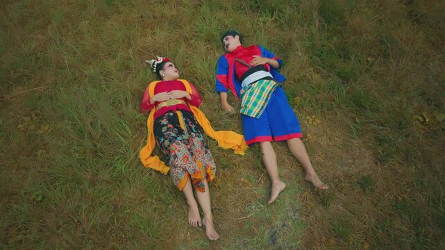 Aerial Style Top Shot of Couple Lying in Green Pasture