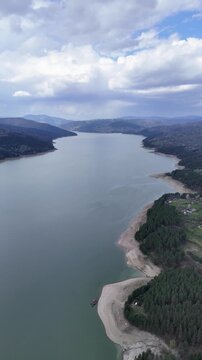 Bicaz Lake aerial view with exposed shore and mountain backdrop