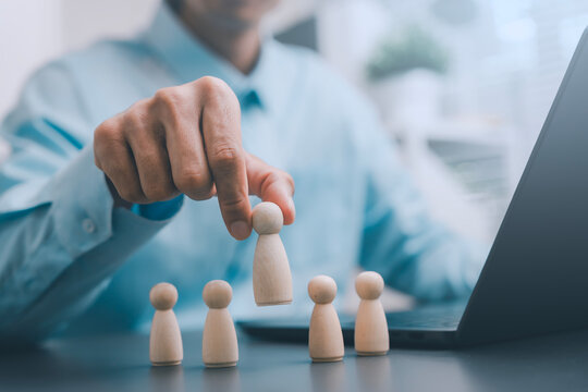 Talent selection human resources recruitment leadership concept business person hand picking wooden peg doll choosing best candidate for promotion team building standing out