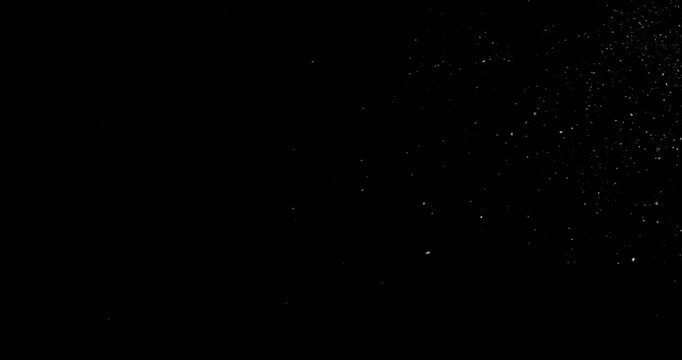 Super slow motion falling snow or dust particles isolated on a black background. Abstract atmospheric SFX overlay with floating debris, cinematic texture and dark visual effect.