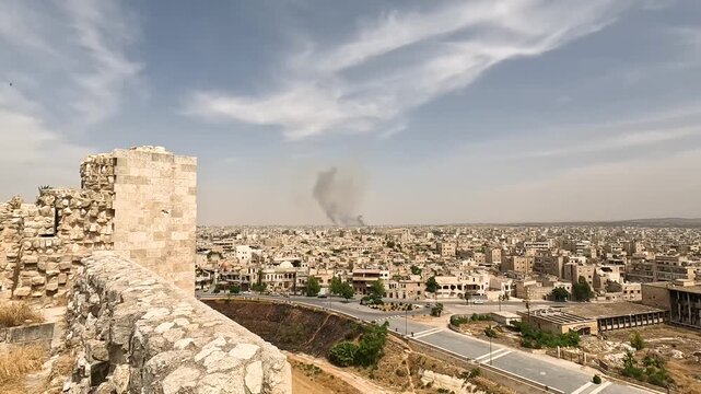 Aleppo Citadel overlooking city skyline with distant smoke plume in Syria in Aleppo, Syria