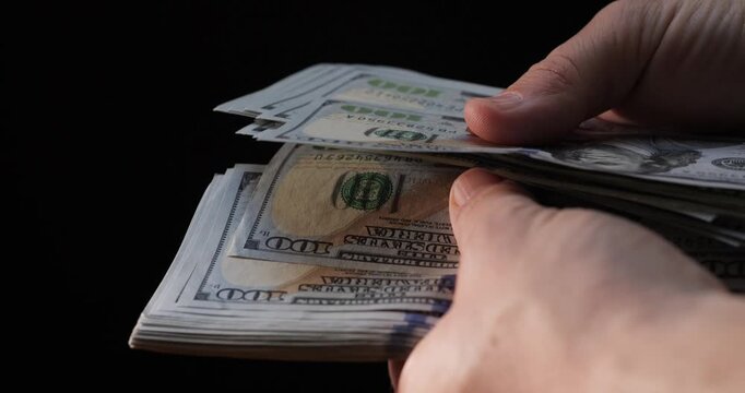 Count dollar bills by hand. 100 dollar bill in a bundle. Count money and income.