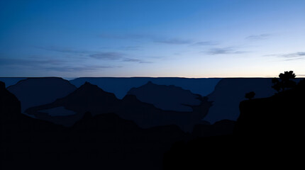 Naklejka premium Silhouetted canyon landscape at dawn in Arizona.