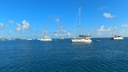 Fototapeta premium Luxury resort photo of French Polynesia tropical paradise island Fakarava with yacht, boat. Photography with blue Pacific ocean, sky with clouds on horizon.