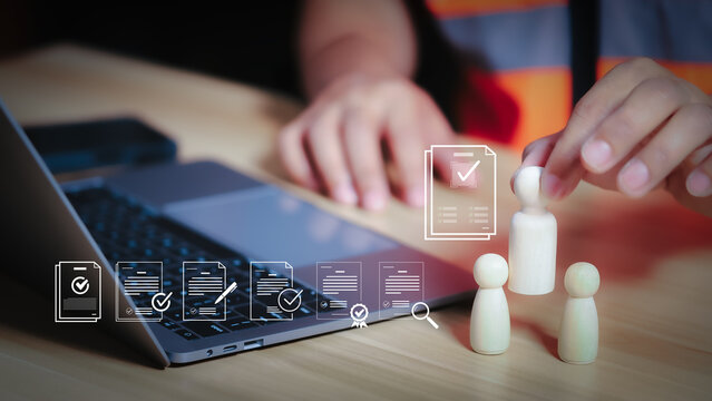HR manager selecting qualified engineer worker from wooden peg dolls on laptop background for industrial recruitment concept. (124 ตัวอักษร) -> ปรับเพิ่มตัวอักษรให้เข้าเกณฑ์: HR manager selecting qual