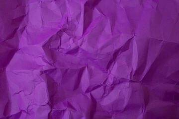 Fototapeta premium Purple colored paper crumpled with shadowed wrinkles, soft focus close up, abstract texture