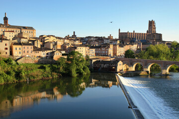 Fototapeta premium Vue d Albi depuis le Tarn, pont-vieux et cathedrale Sainte-Cecile sous un ciel bleu, vieux quartier medieval en brique rouge, patrimoine UNESCO