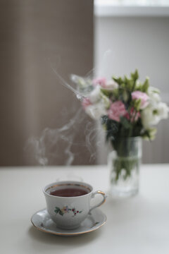 Home cozy still life scene. Table composition with cup of coffee, tea and flowers. Beautiful floral bouquet with roses
