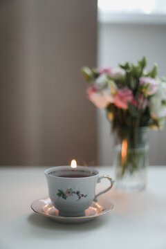 Home cozy still life scene. Table composition with cup of coffee, tea and flowers. Beautiful floral bouquet with roses