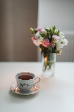 Home cozy still life scene. Table composition with cup of coffee, tea and flowers. Beautiful floral bouquet with roses