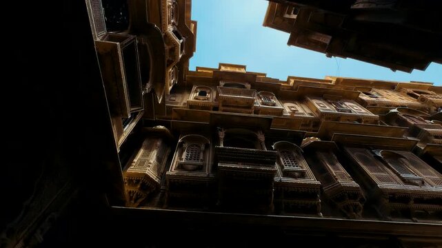 Jaisalmer, India. A Stunning Architectural View of Intricately Designed Historical Buildings Bathed in Golden Light Beneath a Bright Blue Sky, Capturing the Essence of Timeless Elegance.