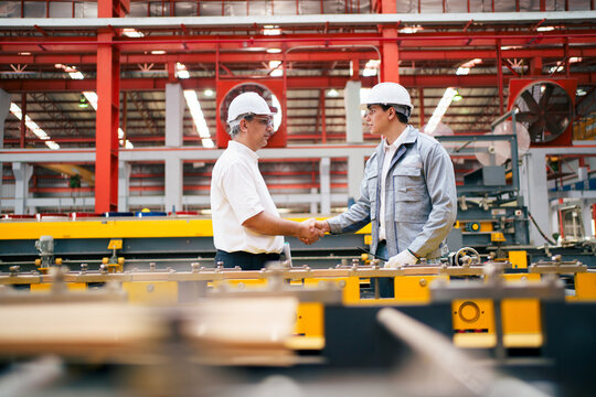 Senior manager and engineer discussing work in factory