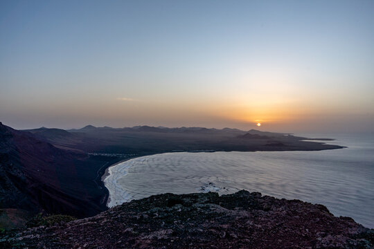 Famara beach sunset from Risco de Famara, Lanzarote, Canary Islands, with Atlantic Ocean and volcanic landscape