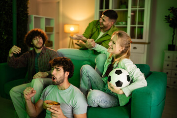 Friends watching exciting soccer game on television at home © Zoran Jesic