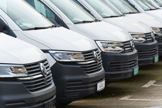 Dusseldorf, Germany - November 22 2025: Row of white Volkswagen vans parked side by side at a commercial vehicle lot