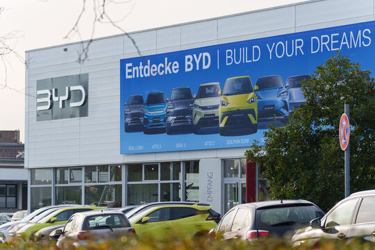 Dusseldorf, Germany - November 22 2025: BYD dealership building with large car advertisement beside a busy roadside