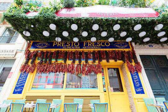 Paris, France-May 16, 2026 : Vibrant Italian osteria Presto Fresco storefront located on Rue Montmartre in 1th district of Paris. featuring a bold yellow facade adorned with cascading strings of dried