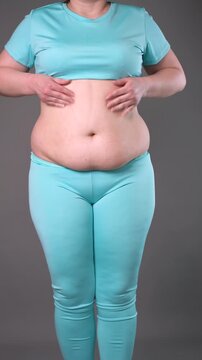 Overweight woman massaging belly fat, stomach self-massage. Weight loss, diet and anti-cellulite body care concept, vertical video