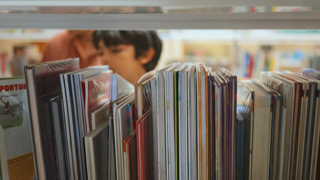 Young student searching for children's books on a library bookshelf, focused on learning and education, highlighting the joy of reading and knowledge acquisition
