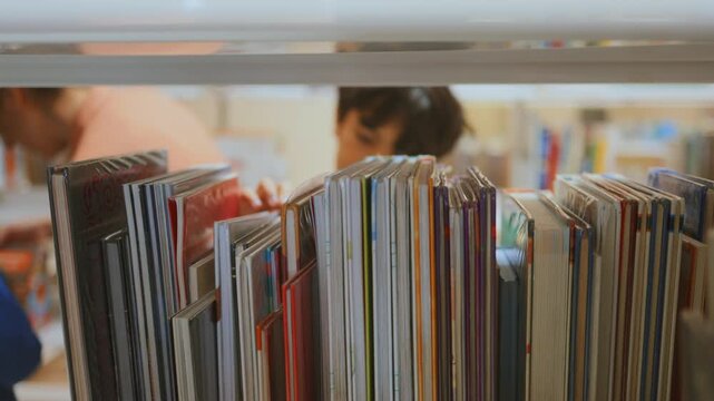 Young student browsing colorful children's books on a library bookshelf, searching for knowledge and educational literature for school learning and reading at leisure